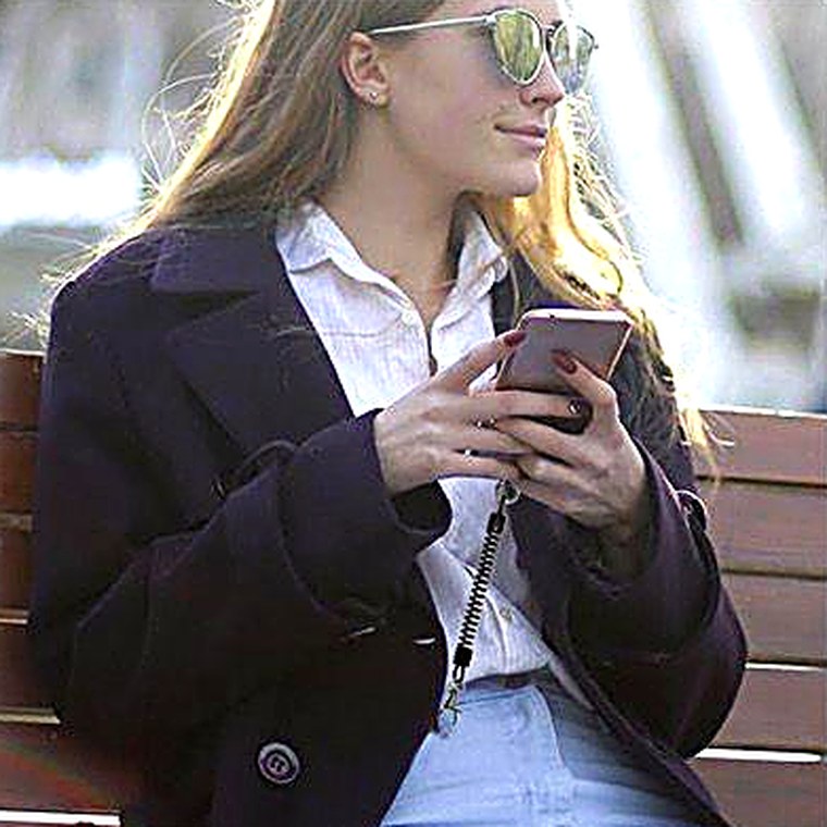 Mujer usando el celular en la calle con PROTEC colgando